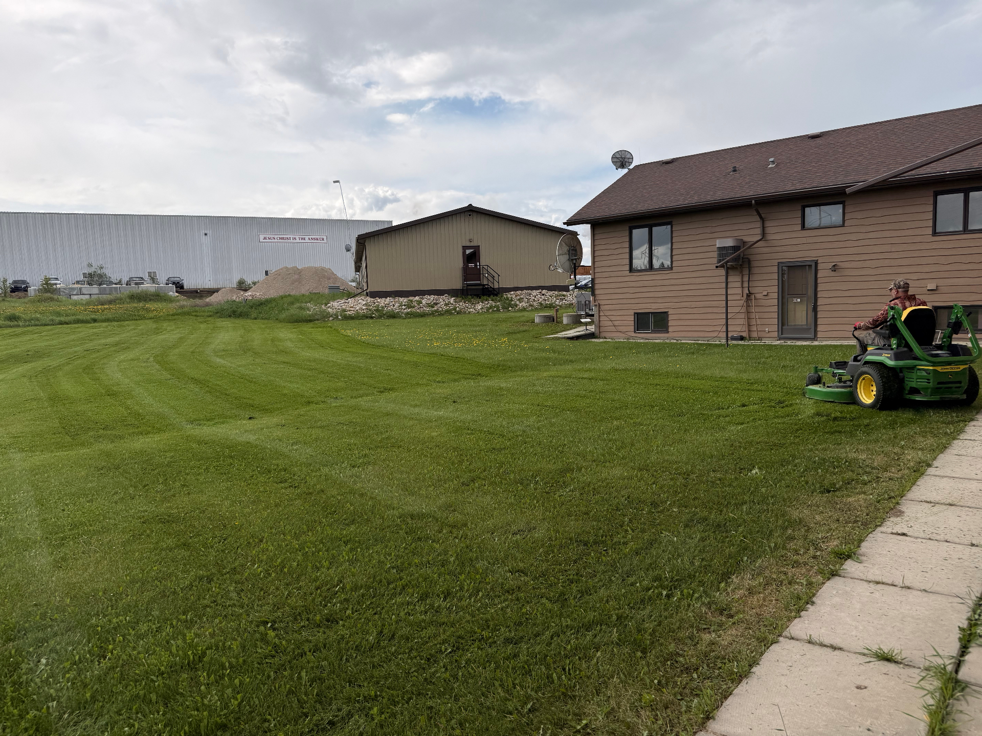 Grow N Mow crew mowing a large property with John Deere mower